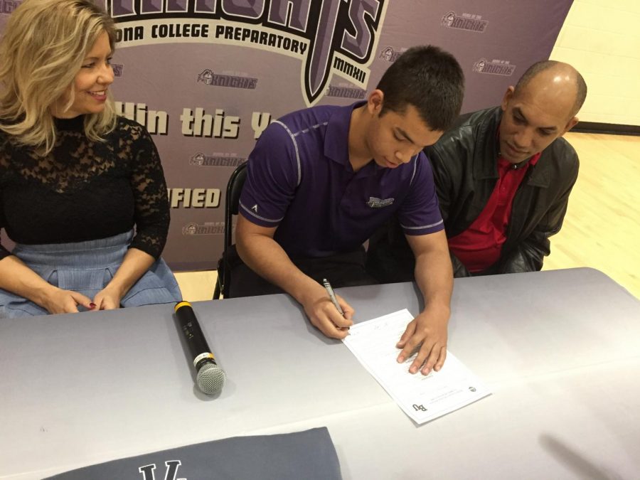 Flanked by his mother and father, Jordan signs his letter of intent. Photo via Caroline Whitesel